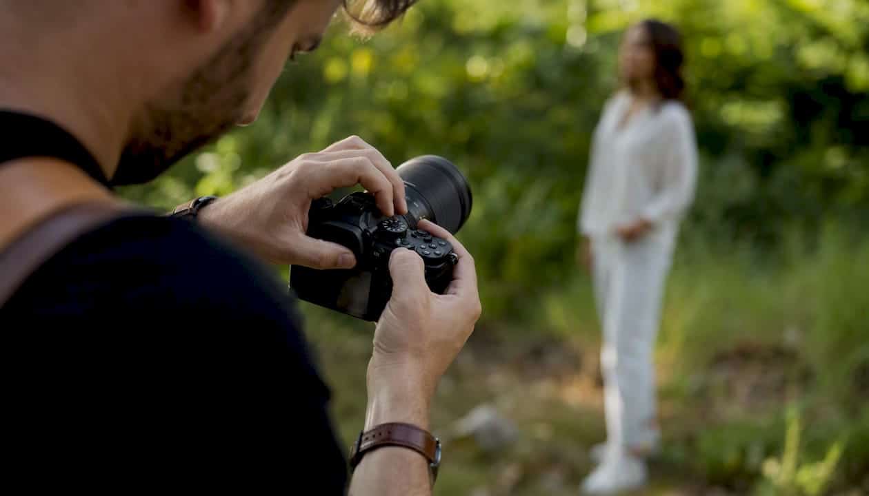 Un photographe règle son appareil photo reflex avant de commencer la séance.