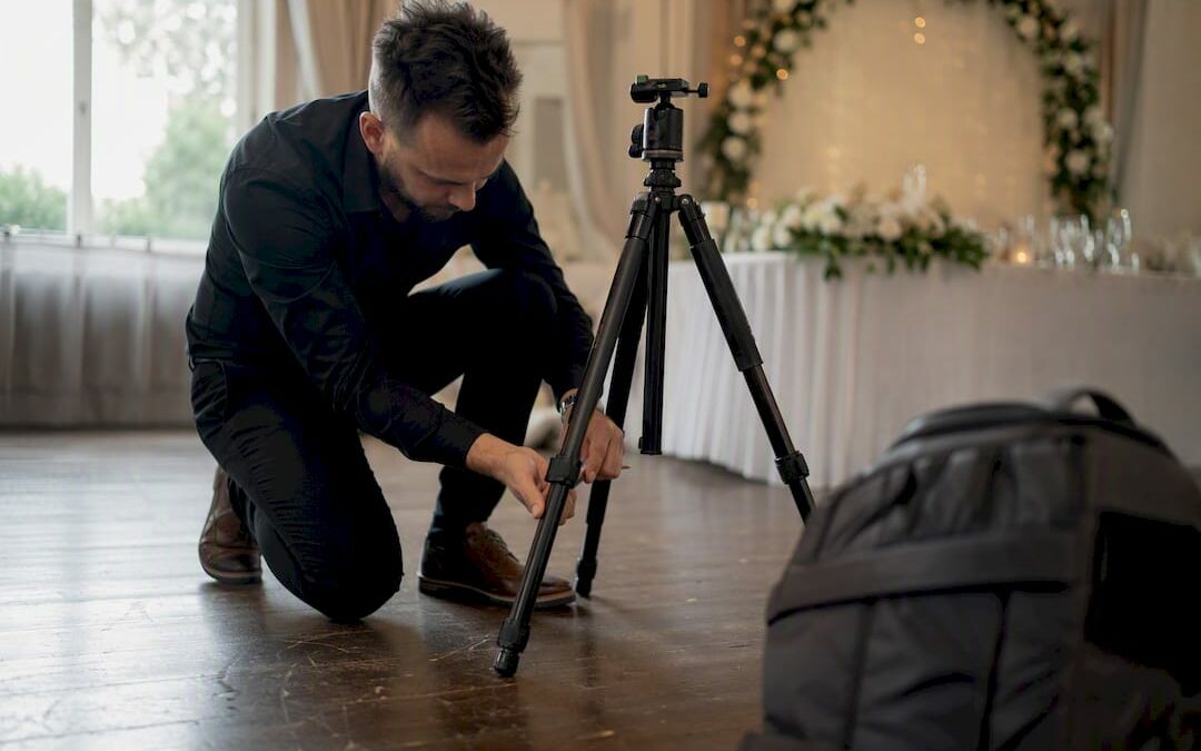 Photographe réglant son trépied sur le lieu du mariage