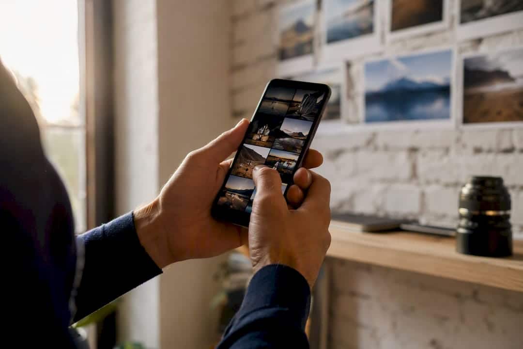 Mains faisant défiler des photos dans la galerie d’un smartphone